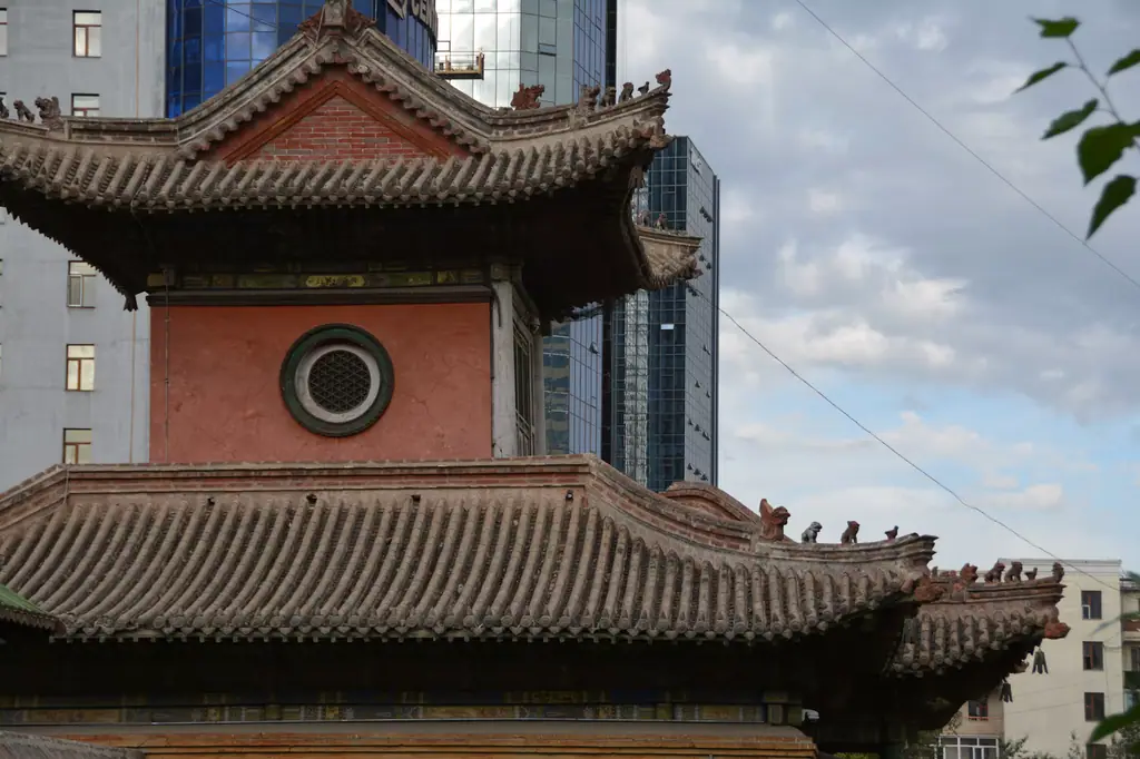 A temple roof against a glass tower in Ulaanbaatar